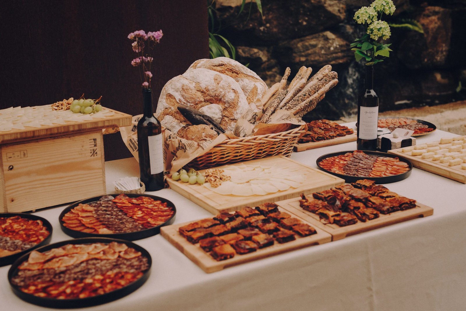 Mesa de aperitivo con tablas de embutido, quesos y pan