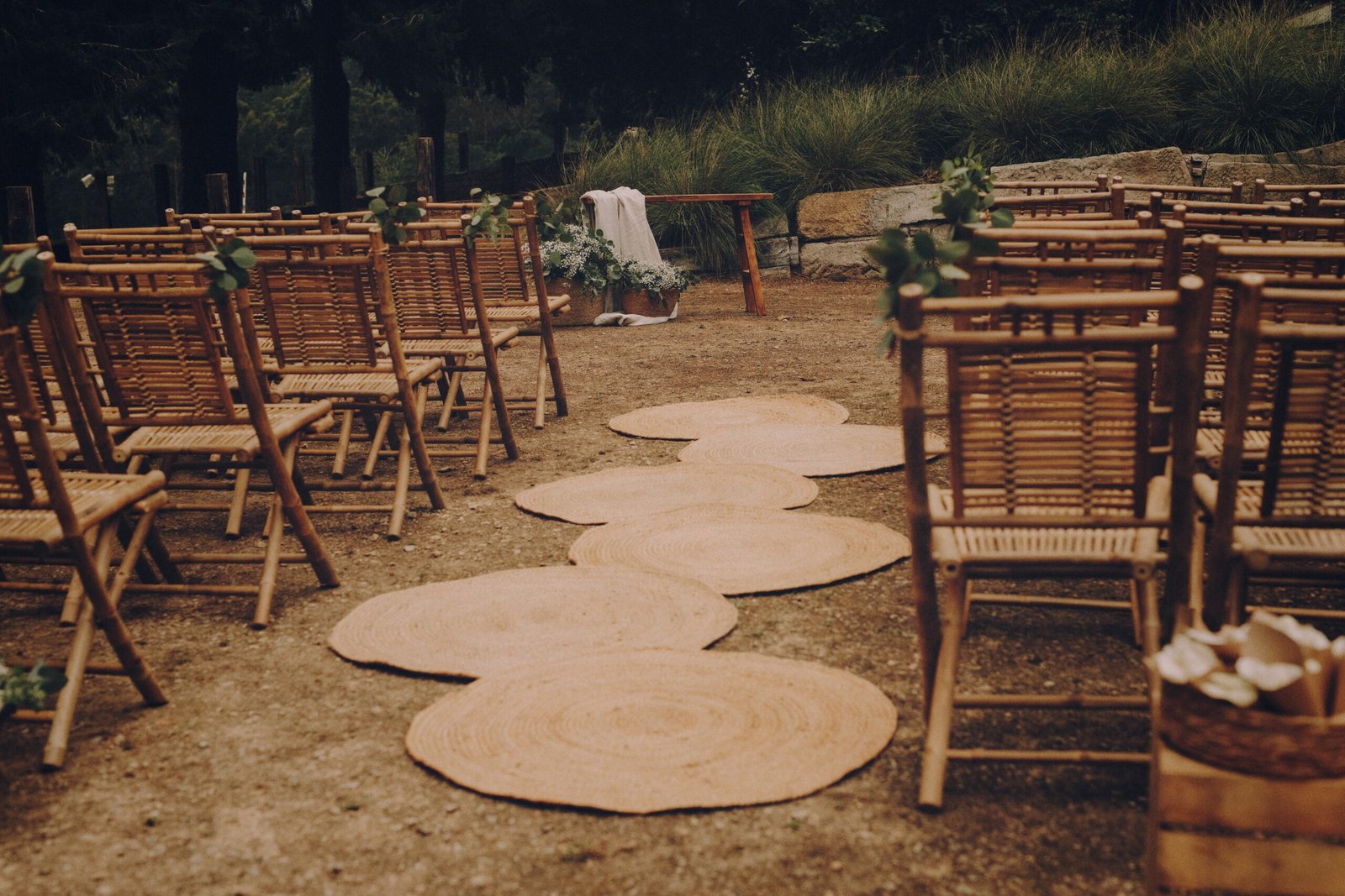 Pasillo de ceremonia entre sillas de bambu, sobre alfombras redondas de yute