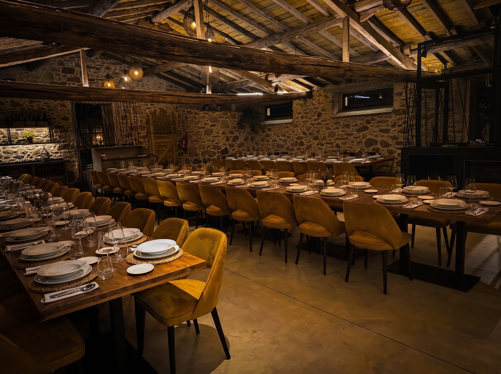 Salon del asador con las mesas vestidas bajo las vigas de madera